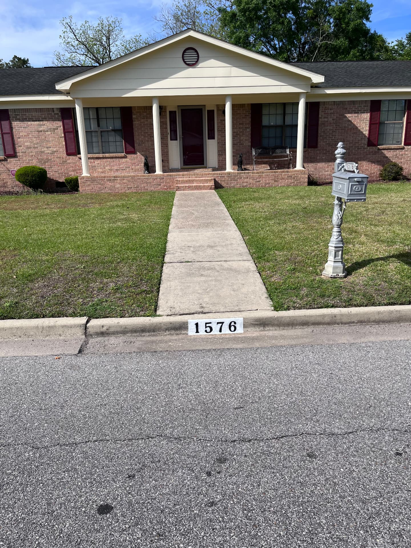 Residential home with a clearly painted 1576 curb address at the street