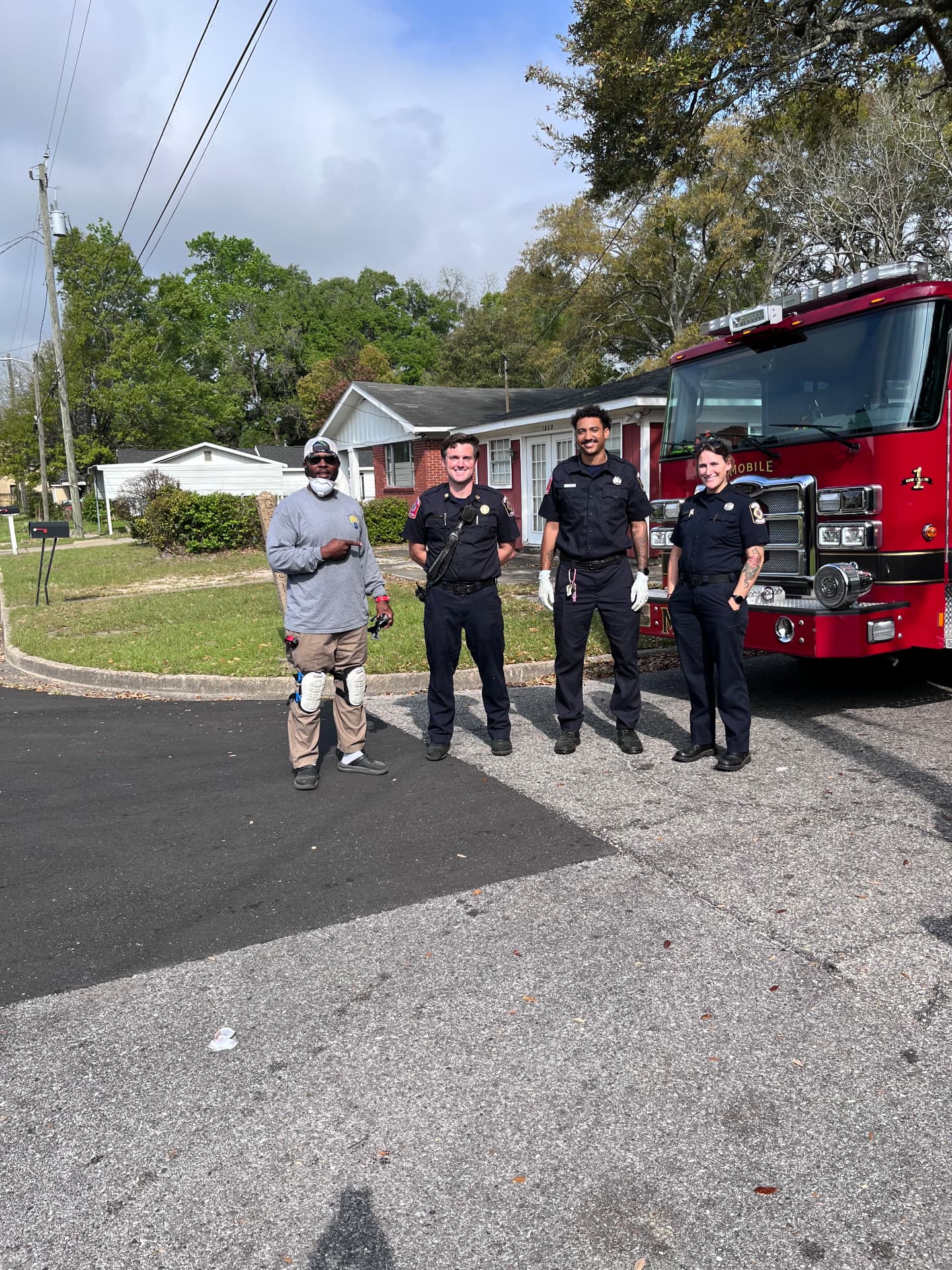 Coach Marlon with Mobile Fire-Rescue crew on a residential street after a curb addressing job